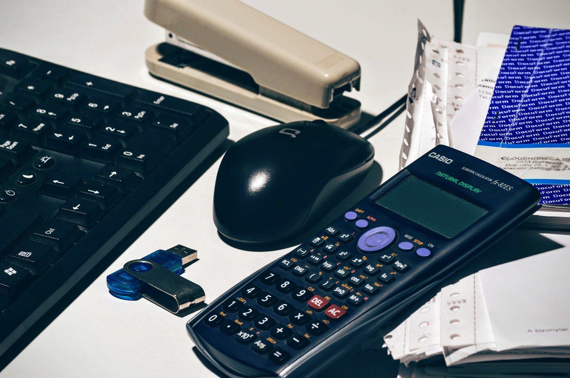 Калькулятор, флешка и другие офисные принадлежности на документах